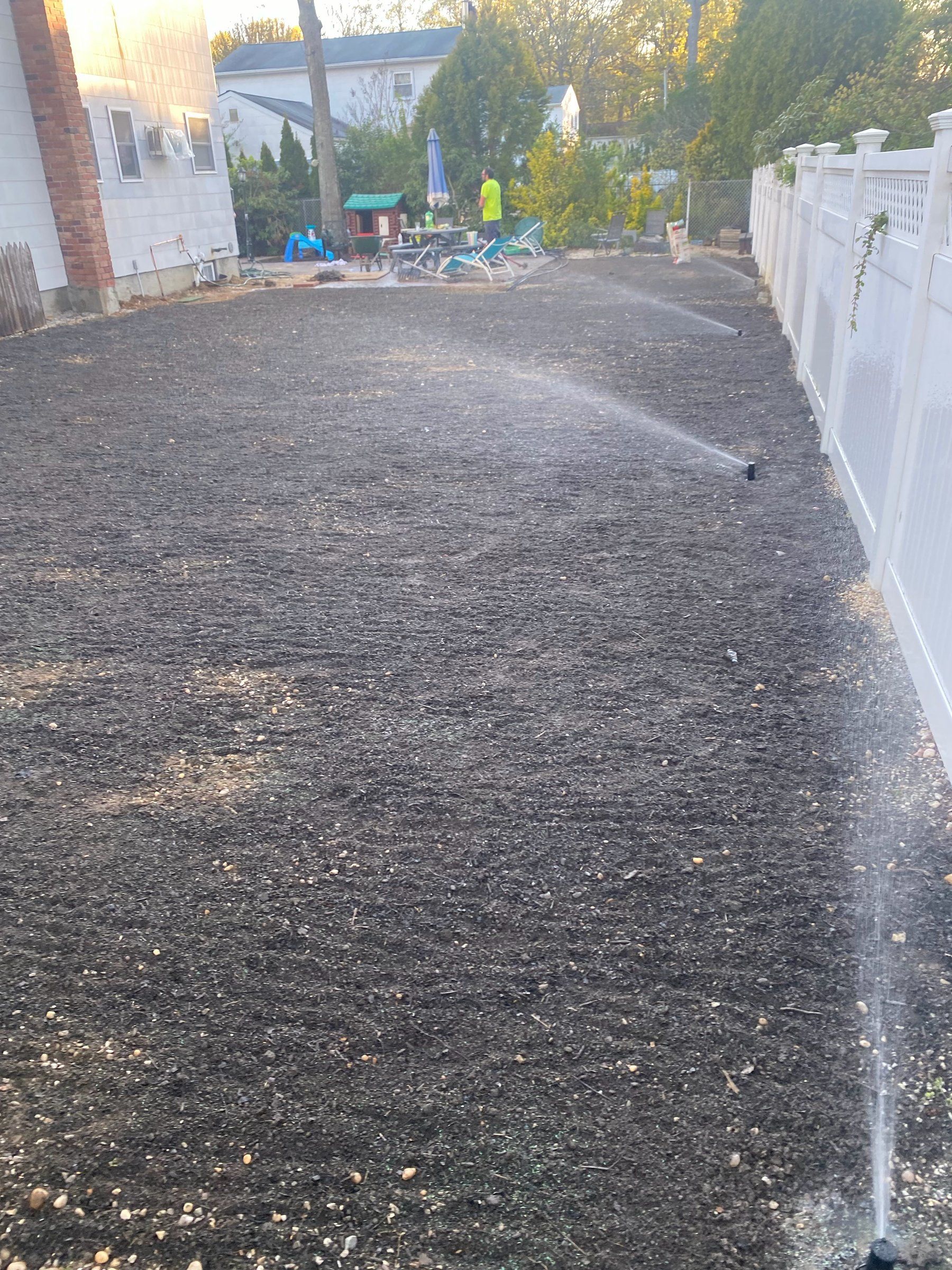 New sprinkler heads watering the freshly seeded yard